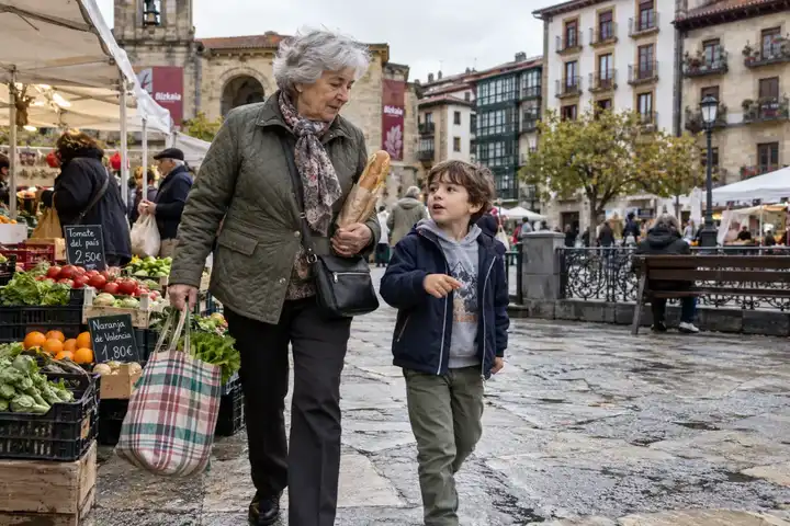 Mujer mayor haciendo la compra con un niño