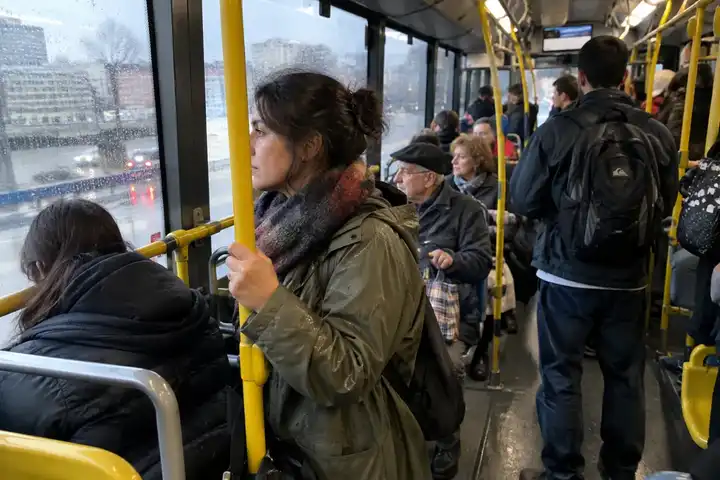 Persona de pie en un autobús urbano