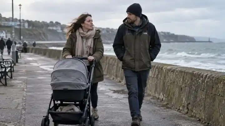 Pareja paseando junto al mar con un carrito