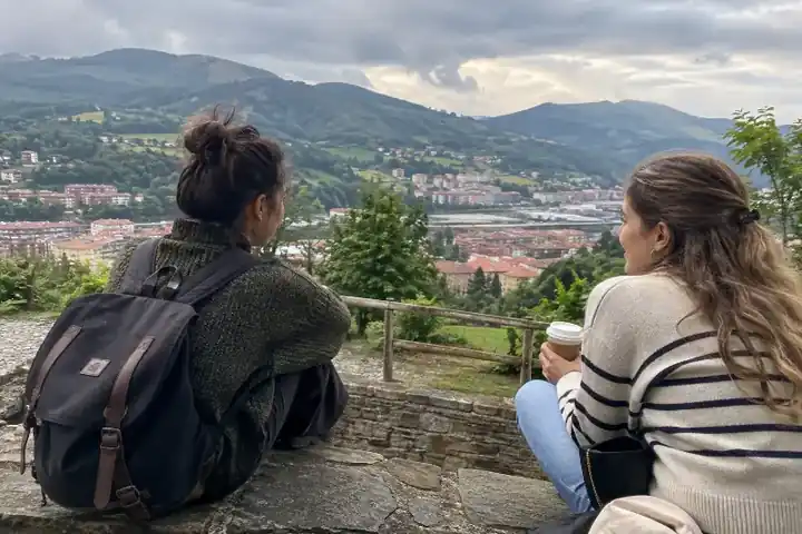 Dos amigas descansando en un mirador con vistas al valle