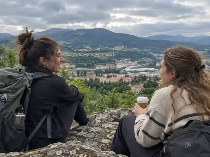 Dos amigas descansando en un mirador durante una ruta