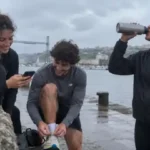 Tres jóvenes descansando después de entrenar junto al agua