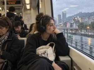 Mujer joven sentada en el transporte público mirando por la ventana