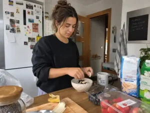 Mujer joven preparando un desayuno con fruta en casa