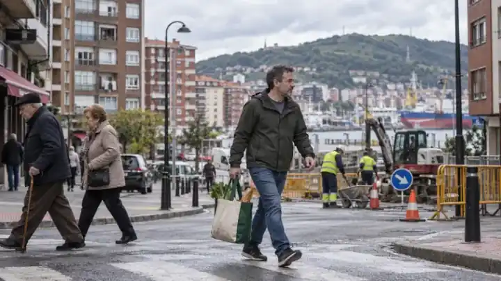Hombre caminando con una bolsa de compra cerca del puerto
