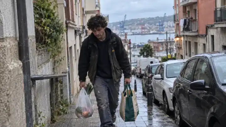 Hombre subiendo una cuesta con bolsas de la compra