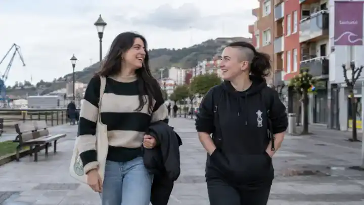 Dos jóvenes caminando y charlando por la calle