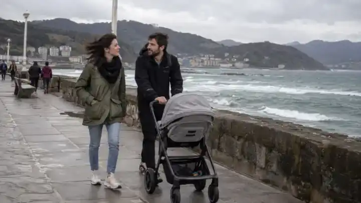 Familia paseando con carrito por un paseo costero