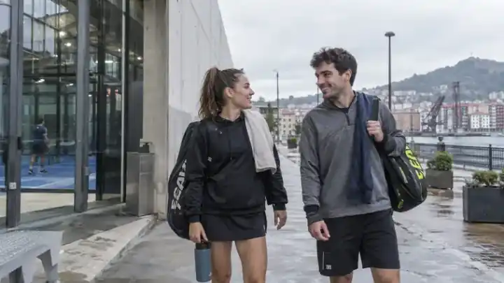 Dos personas caminando con bolsas después de entrenar