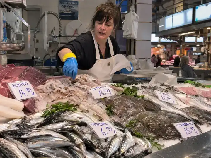 Pescadera preparando pescado en un mercado local