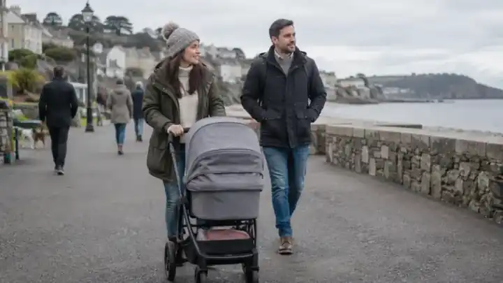 Pareja paseando con un carrito por el paseo marítimo