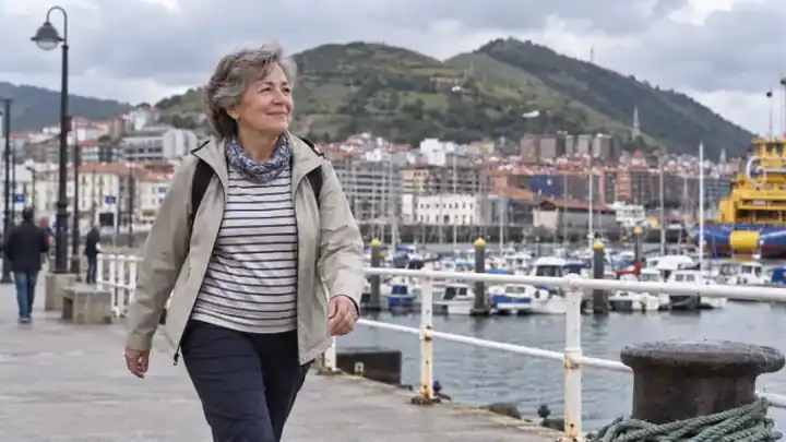 Mujer mayor paseando junto al puerto durante su rutina diaria